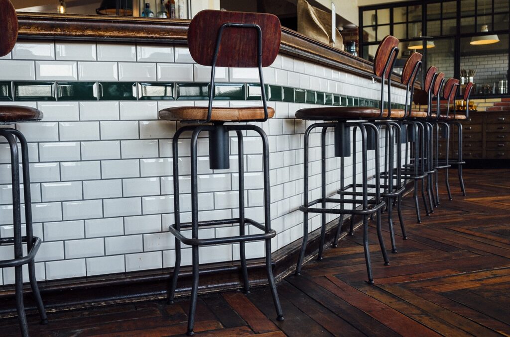 Commercial cleaning London bar interior with tiled counter, wooden stools, and timber flooring