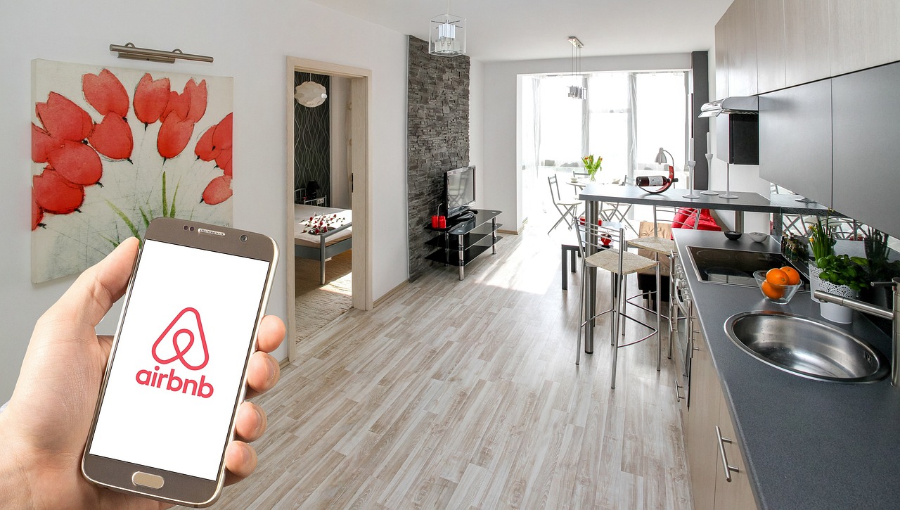 Airbnb cleaning London short let apartment with open plan kitchen and dining area and Airbnb app shown on a smartphone