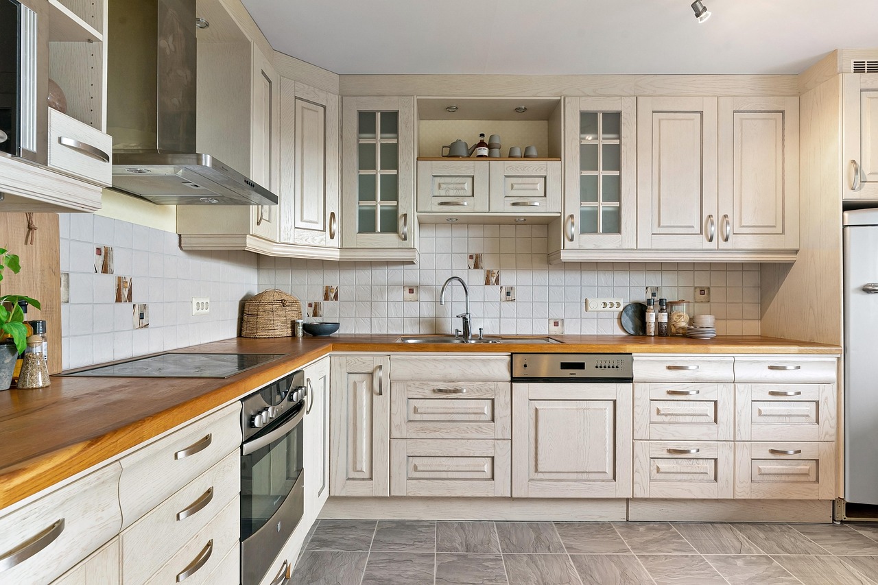 End of tenancy cleaning London kitchen with pale cabinets, wooden worktops, tiled backsplash, and built in oven